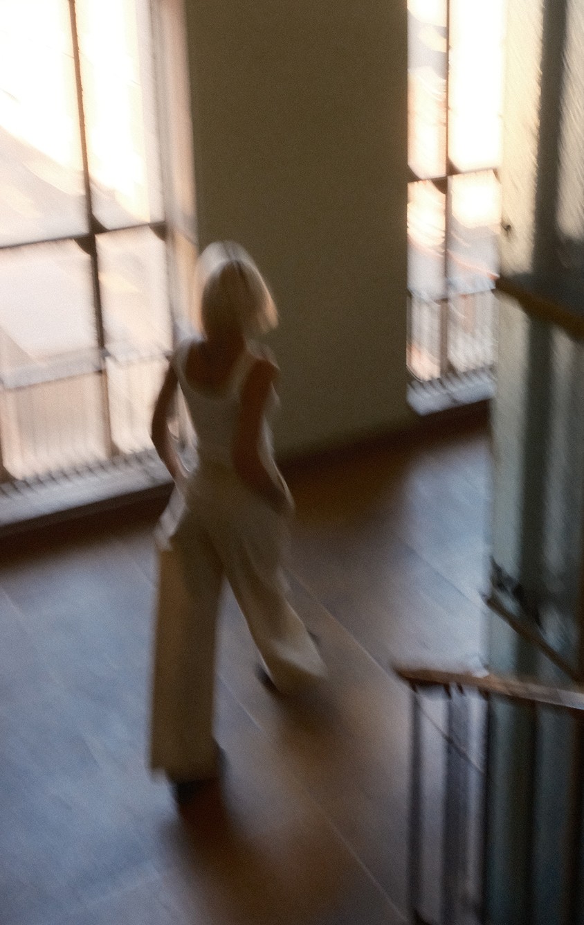 Jana-Berit Osborn walking through a sunlit stairwell
